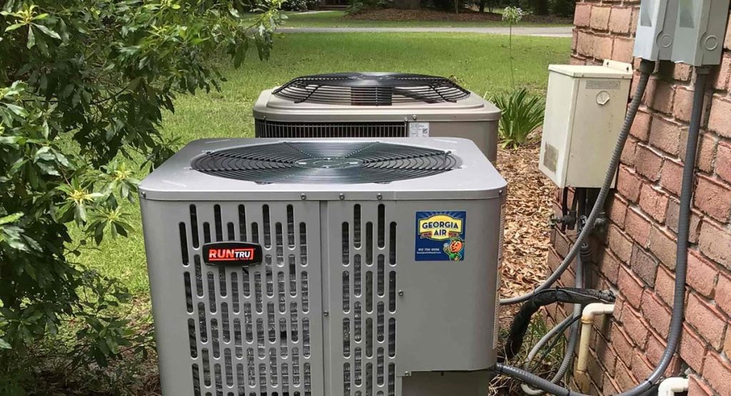 AC unit with Georgia Air sticker beside a brick wall