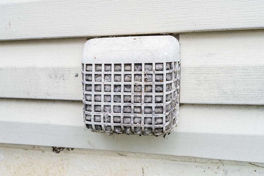 Clogged exterior dryer vent covered in lint