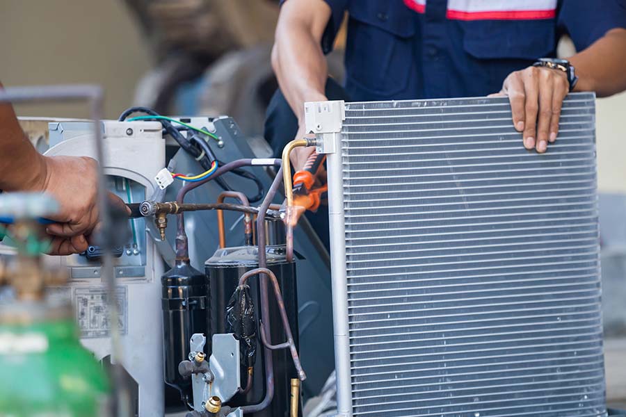 AC repair technician welding condenser