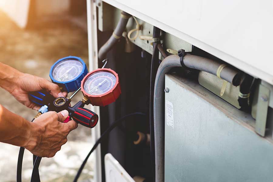 Technician servicing a residential AC unit during a Freon recharge in Richmond Hill, GA